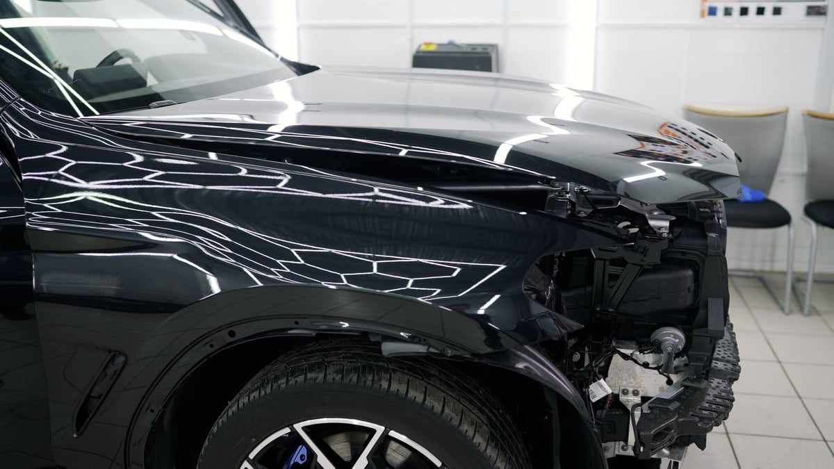 Mechanics restoring a damaged car to its original condition in a repair shop